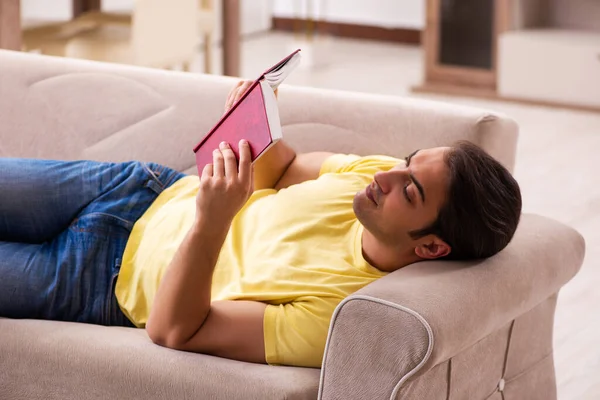 Evde kitap okuyan genç bir erkek öğrenci. — Stok fotoğraf