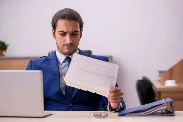 Jonge mannelijke werknemer verbrandt papieren in het kantoor — Stockfoto