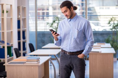 Sınıftaki genç erkek öğretmen.