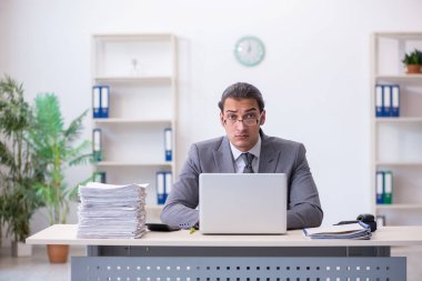 Ofisteki aşırı işten memnun olmayan genç bir erkek işçi.