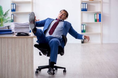 Ofisteki aşırı işten memnun olmayan genç bir erkek işçi.