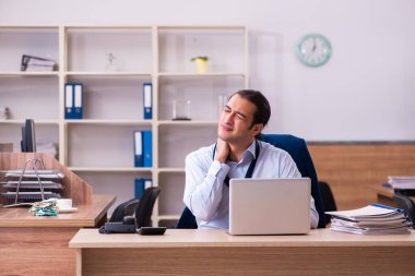 Genç erkek çalışan işyerinde osteokondrosis hastası.