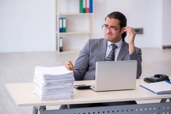 Ung manlig anställd missnöjd med överdrivet arbete på kontoret — Stockfoto