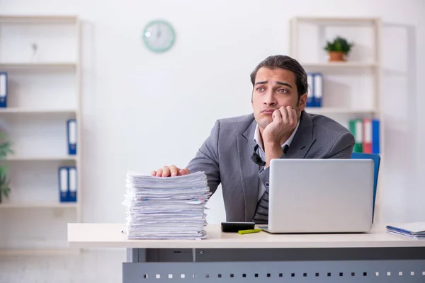 Joven empleado masculino descontento con el trabajo excesivo en la oficina — Foto de Stock