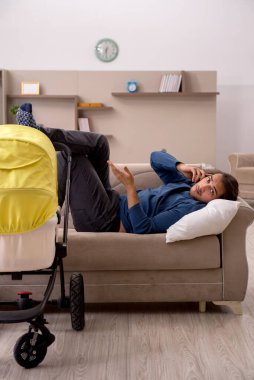 Evde bebekle ilgilenen genç bir müteahhit.