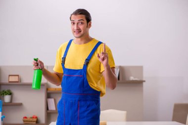 Genç erkek müteahhit evi temizliyor.