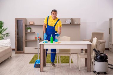 Genç erkek müteahhit evi temizliyor.