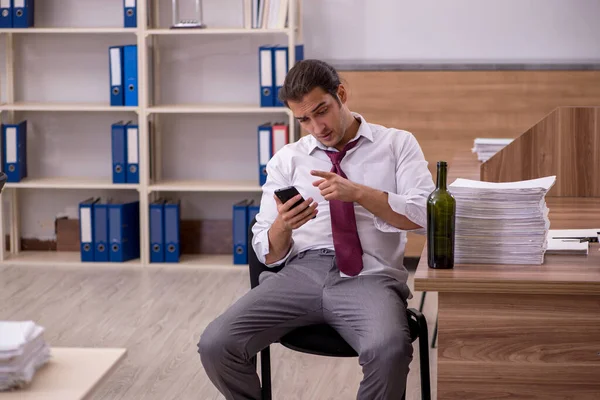 Young male employee drinking alcohol in the office — Stock Photo, Image