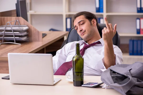 Young male employee drinking alcohol in the office — Stock Photo, Image