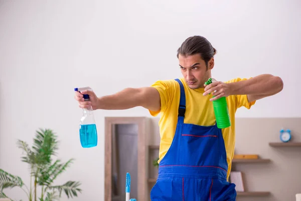 Joven contratista masculino limpiando la casa —  Fotos de Stock