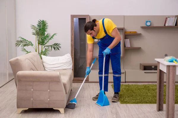 Joven contratista masculino limpiando la casa — Foto de Stock