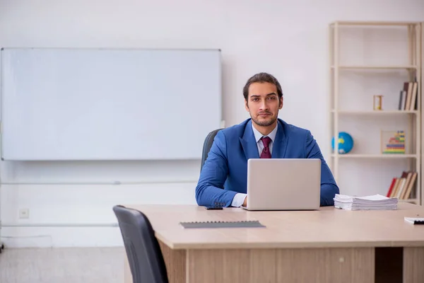 Jeune employé masculin assis dans le bureau devant le tableau blanc — Photo