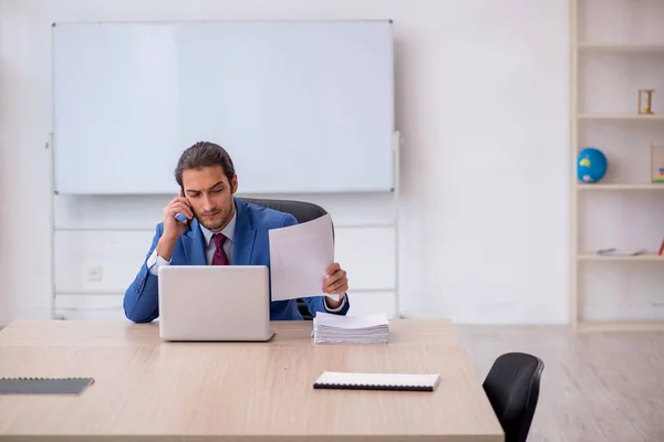 Junge männliche Mitarbeiter sitzen im Büro vor Whiteboard — Stockfoto