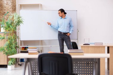 Sınıftaki genç erkek öğretmen.