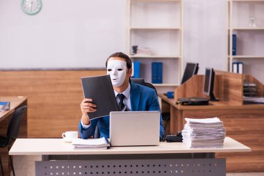 Ofiste maske takan genç bir erkek.