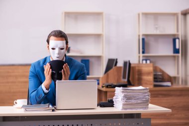 Ofiste maske takan genç bir erkek.