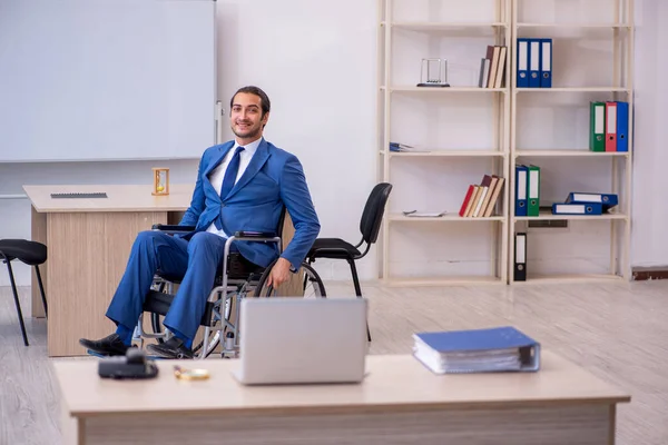 Jovem empregado do sexo masculino em cadeira de rodas trabalhando no escritório — Fotografia de Stock