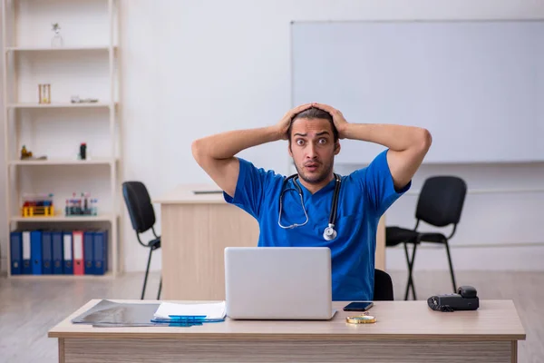 Ung manlig läkare som arbetar på kliniken — Stockfoto