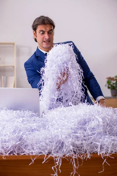 Mladý muž a spousta řezaných papírů v kanceláři — Stock fotografie