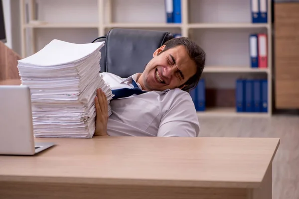 Jovem funcionário masculino infeliz com excesso de trabalho no escritório — Fotografia de Stock