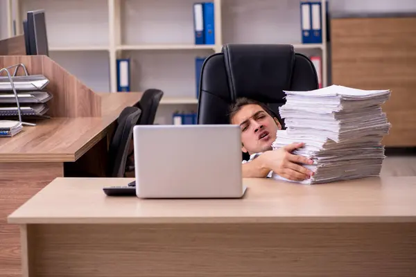 Joven empleado masculino descontento con el trabajo excesivo en la oficina — Foto de Stock