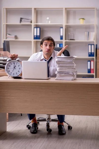 Giovane dipendente maschile nel concetto di gestione del tempo in ufficio — Foto Stock