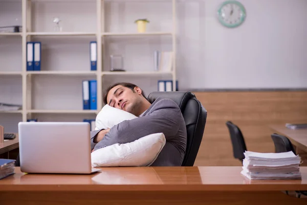 Jovem empregado dormindo no local de trabalho — Fotografia de Stock