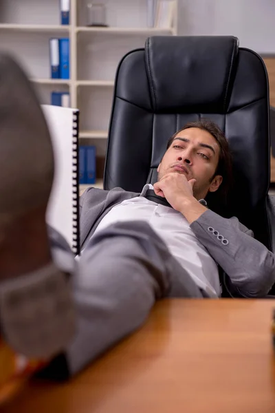 İş yerinde uyuyan genç bir erkek işçi. — Stok fotoğraf
