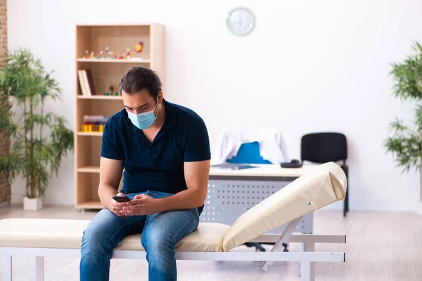 Jeune homme attendant un médecin pendant une pandémie à l'hôpital — Photo