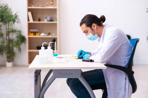Joven químico masculino trabajando en el laboratorio durante una pandemia — Foto de Stock