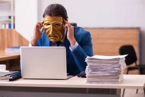 Jeune employé masculin portant un masque triste au bureau — Photo