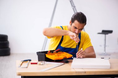 Genç erkek marangoz içeride çalışıyor.