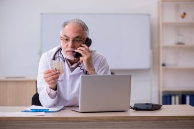Teletıp konseptinde yaşlı bir doktor.