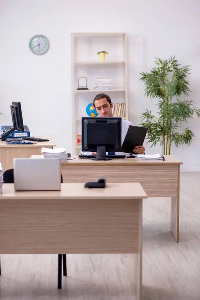 Junge männliche Angestellte sitzen im Büro — Stockfoto