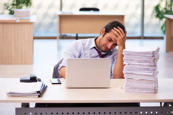 Jovem funcionário masculino infeliz com excesso de trabalho no escritório — Fotografia de Stock