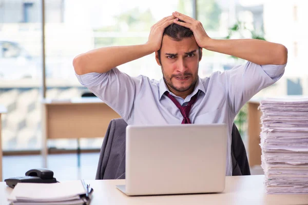 Jovem funcionário masculino infeliz com excesso de trabalho no escritório — Fotografia de Stock