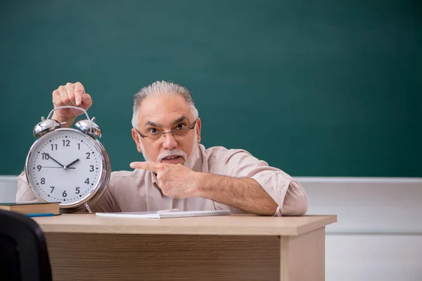 Oude mannelijke leraar in time management concept — Stockfoto