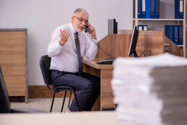 Old male employee unhappy with excessive work in the office