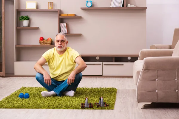 Homme âgé faisant des exercices sportifs à la maison — Photo