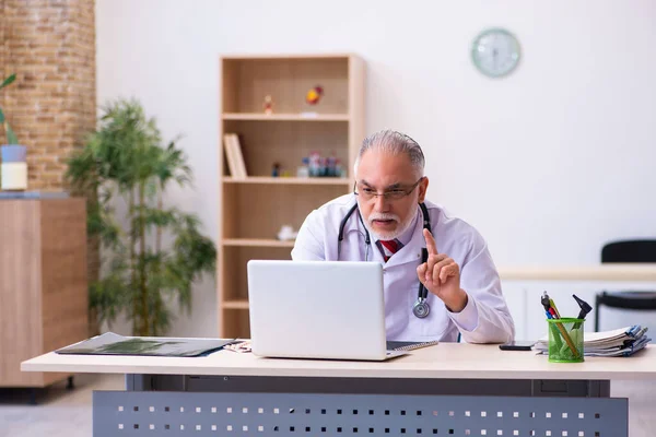 Klinikte çalışan yaşlı erkek doktor. — Stok fotoğraf