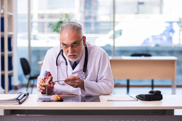 Gammal manlig läkare kardiolog arbetar på kliniken — Stockfoto