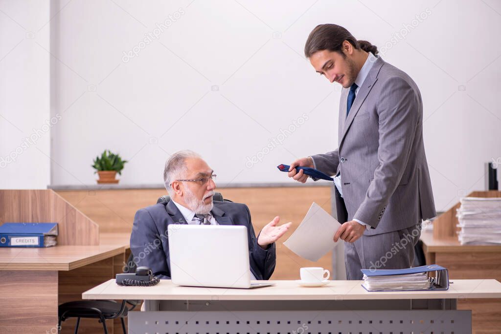 Old boss and young male assistant in the office