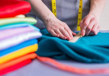 Kadın terzi dikiş dikmek için dikiş dikiyor.