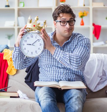 Genç adam dağınık bir odada çalışıyor.