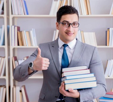 Kütüphanede çalışan yığınla kitabı olan bir işletme hukuk öğrencisi.