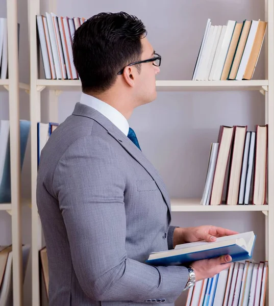 Zakenman student die een boek leest dat in de bibliotheek studeert — Stockfoto