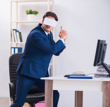 Çalışan ofiste sanal gerçeklik gözlüğü kullanıyor.