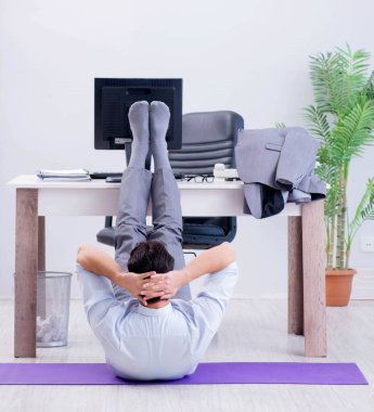 İş adamı tatilde ofiste spor yapıyor.