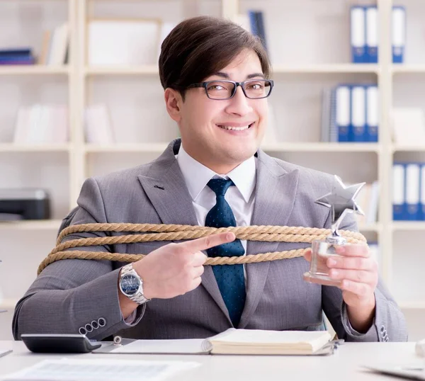 Businessman tied up with rope in office — Stock Photo, Image