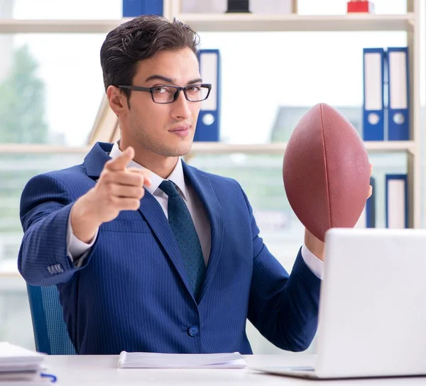 Бизнесмен с американским футболом в офисе — стоковое фото